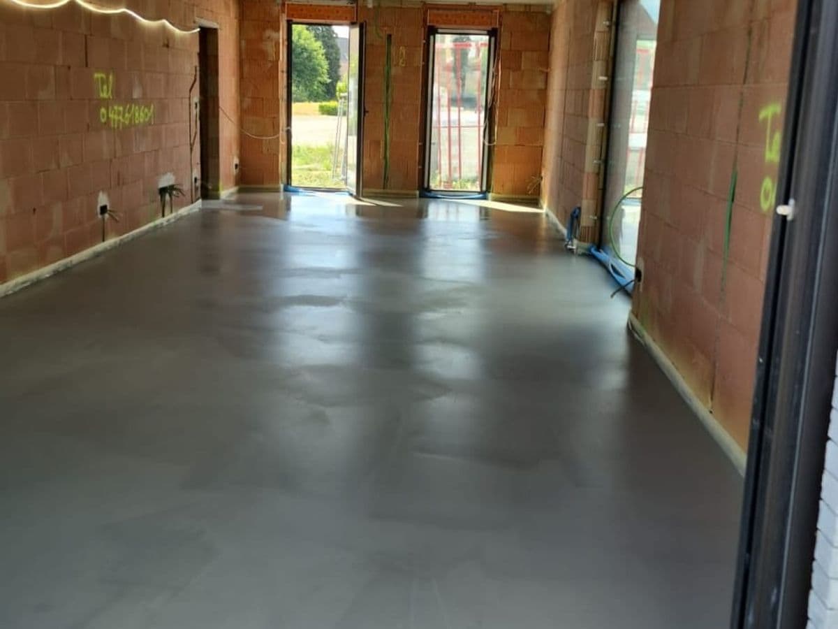 Nieuwbouw met een pas gegoten chape tussen ruwe bakstenen muren