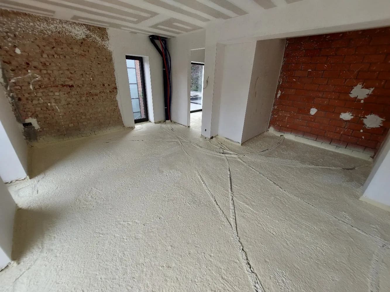 Renovatie met gespoten PUR-vloerisolatie waarin de leidingen volledig zijn ingewerkt